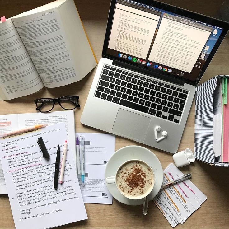 A workspace featuring a laptop, coffee, and books, representing content writing at Digitixel Marketing.