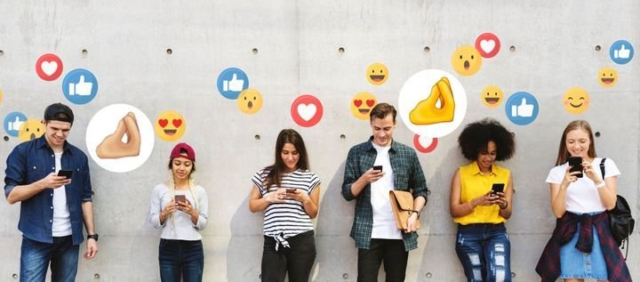 People stand together in front of a vibrant wall featuring social media icons, highlighting the importance of online interaction.