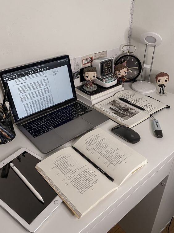 A desk featuring a laptop, books, and writing tools, symbolizing content writing at Digitixel Marketing.