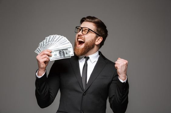 A businessman in formal attire holds up cash, representing the financial benefits of effective marketing strategies.